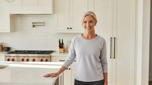 Confident active adult woman standing comfortably and steadily in a bright modern kitchen, framed above the ankles