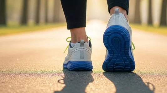 G-Defy Mighty Walk gray-blue athletic shoes mid-stride on a sunlit park path, comparing running and walking footwear