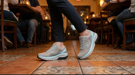 Restaurant server mid-pivot on a tile dining room floor wearing grey G-Defy Mighty Walk restaurant work shoes