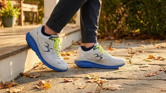 Close-up of G-Defy Mighty Walk closed walking shoes stepping from a doorstep onto an autumn leaf-covered path