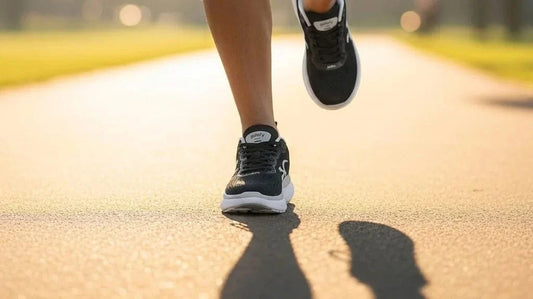Runner mid-stride on a sunlit park path wearing black G-Defy XLR8 Run comfortable running shoes with white cushioned midsoles