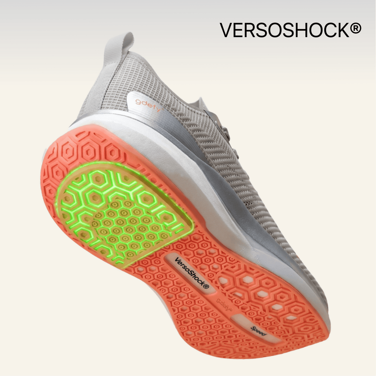 Grey GDEFY sneaker, angled to show the coral VersoShock® outsole with a prominent vibrant green cushioning insert.