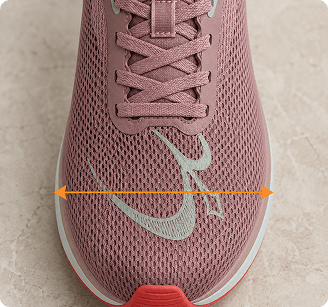 Dusty rose mesh running shoe with light green Nike swoosh, pink laces, and measurement arrows on the forefoot.
