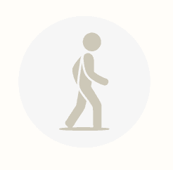 Icon of a person walking, depicted in a light brown silhouette within a pale gray circular background.