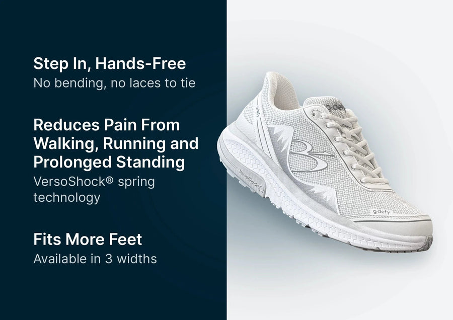 White G-Defy athletic shoe with a mesh upper, thick VersoShock sole, and subtle gray accents, angled view.