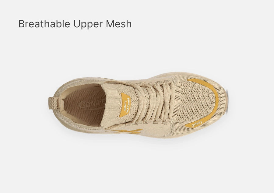 Beige sneaker with breathable mesh upper and yellow accents, shown from a top-down view.