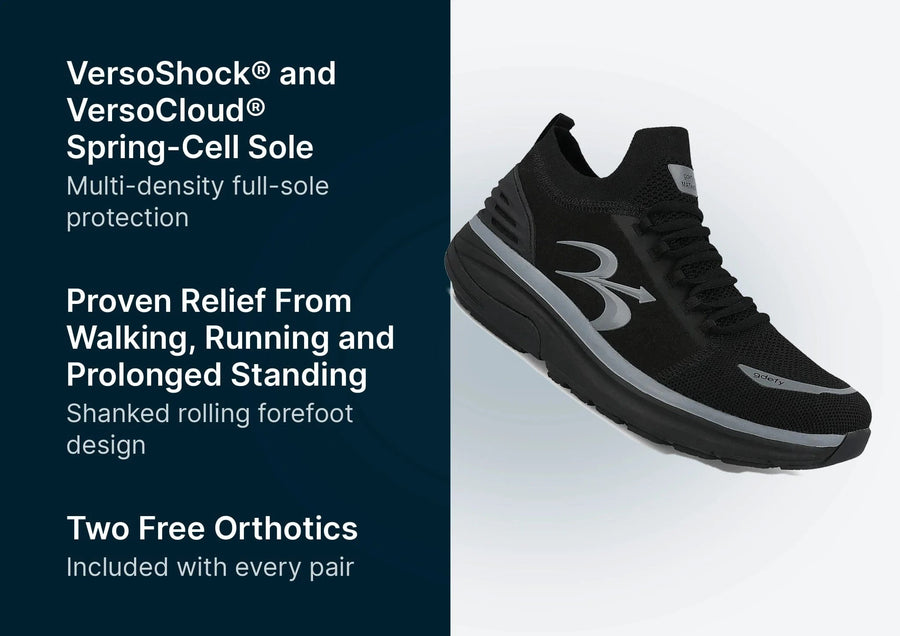 Black athletic shoe with mesh upper, gray accents, and a thick VersoShock® Spring-Cell Sole, angled to show its side.
