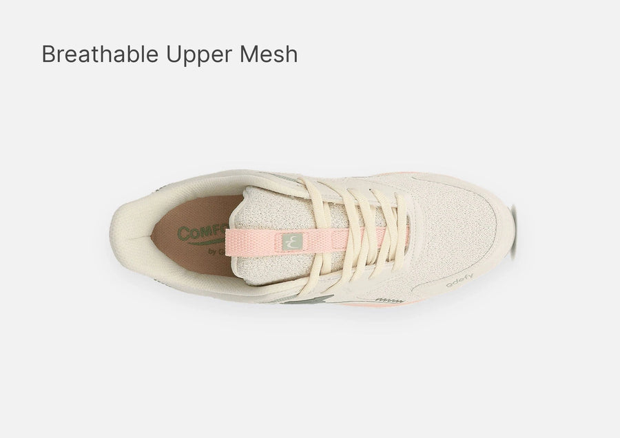 Cream athletic shoe with cream laces, breathable mesh upper, and pink accents, viewed from above.