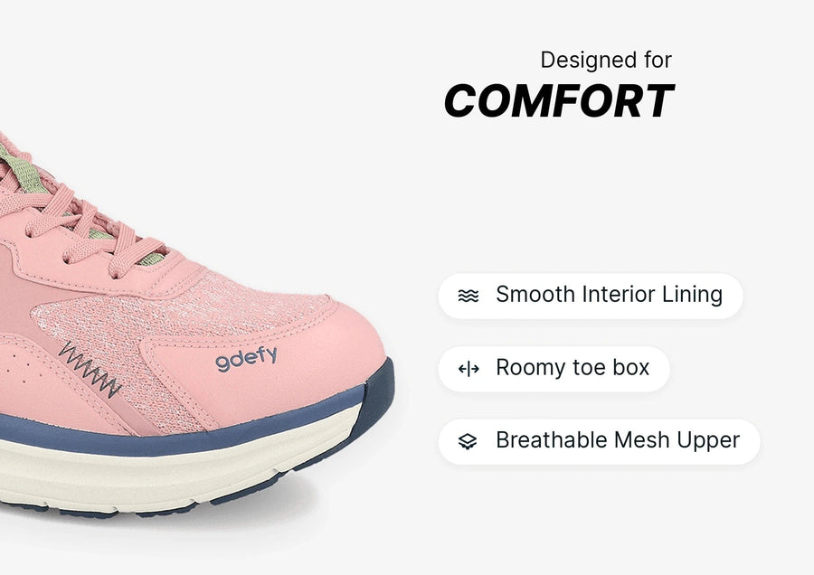 Pink gdefy sneaker with green laces, highlighting comfort features like smooth lining, roomy toe box, and breathable mesh upp