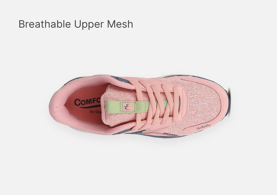 Pink athletic sneaker with a breathable mesh upper, pink laces, and light green accents, featuring a "Comfo" insole.