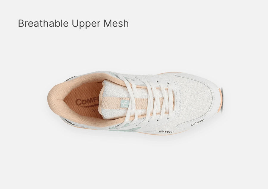 White athletic shoe with a breathable mesh upper, peach collar lining, and light blue accents, seen from a top-down view.