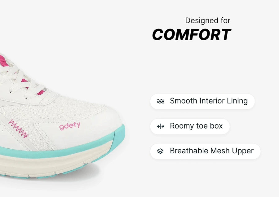 White sneaker with pink laces and teal sole accents, featuring a breathable mesh upper and roomy toe box for comfort.
