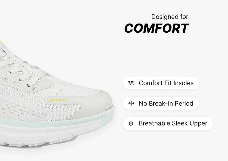 White sneaker with breathable mesh upper and light green sole, highlighting comfort fit insoles and no break-in period.