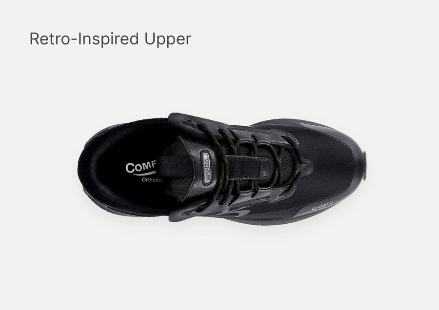 Black athletic shoe, top-down view, featuring a retro-inspired upper and "Comf Orthotics" branding.