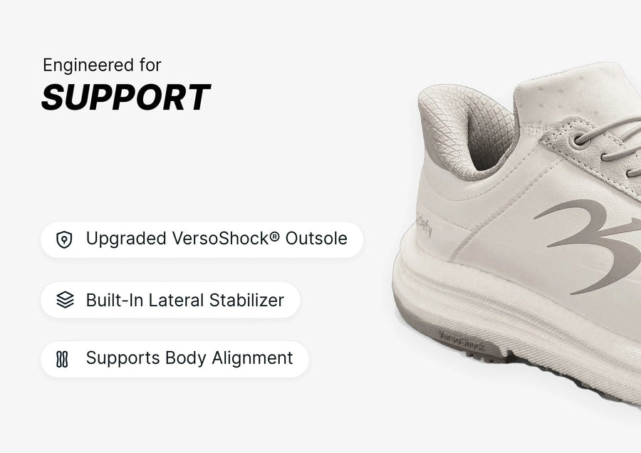 White athletic shoe, side view, showcasing its supportive design with a thick VersoShock outsole and lateral stabilizer.