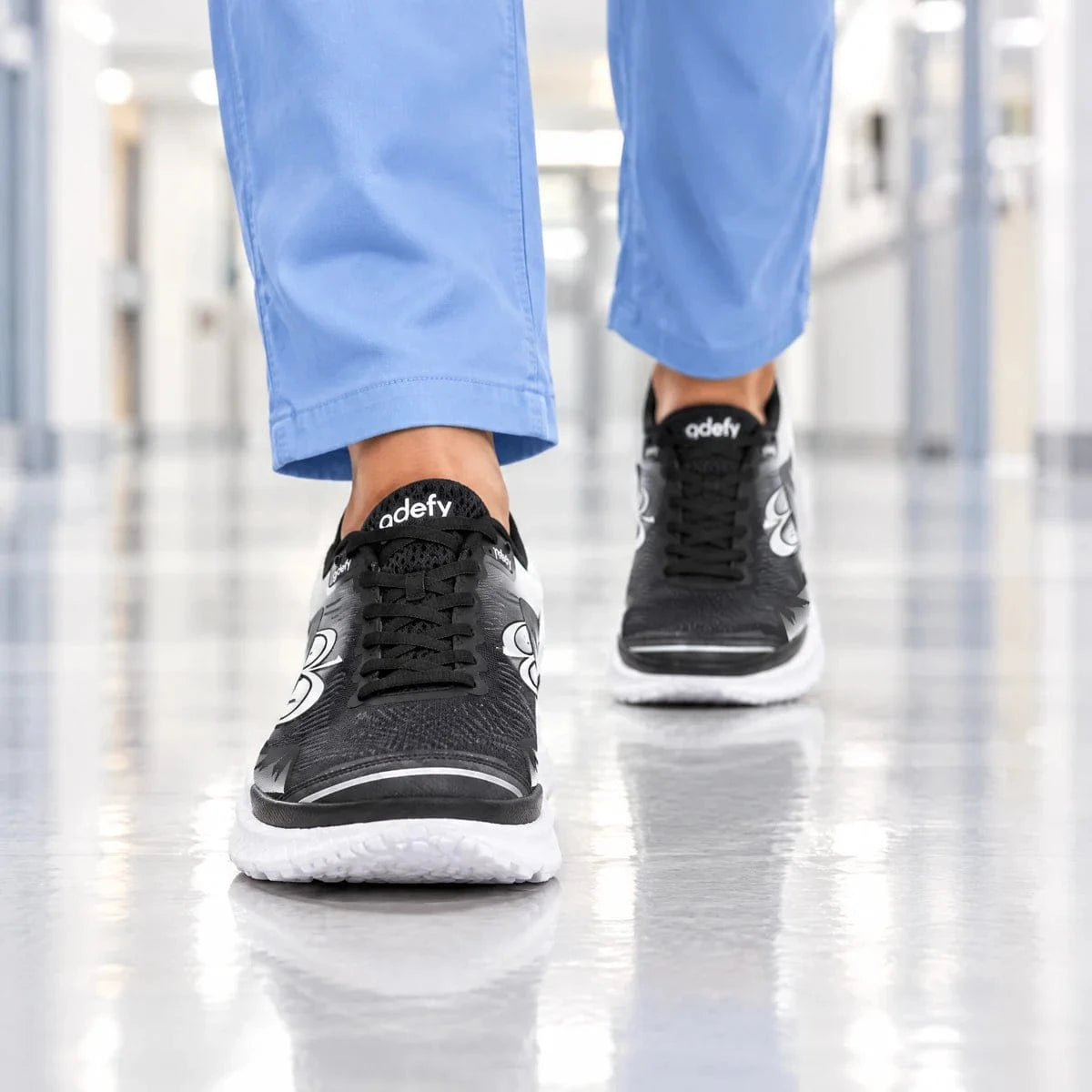 Front-view illustrative scene of a woman walking toward the camera in GDEFY footwear